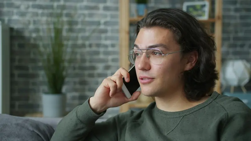 Une personne au téléphone chez elle
