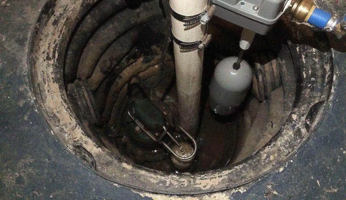 Pompe immergée qui vide une cave, tuyau qui remonte